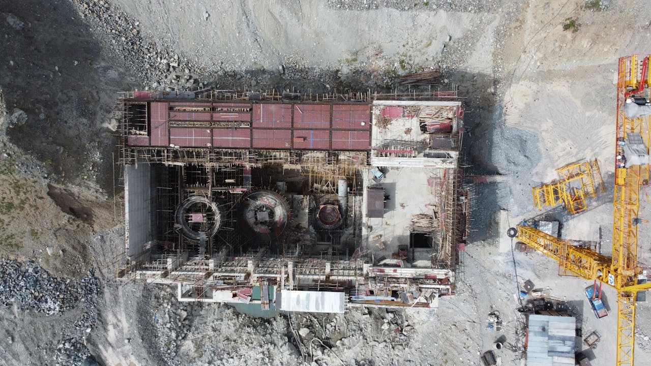 Aerial shot of a construction site with cranes in Matiltan, Pakistan, showcasing industrial progress.