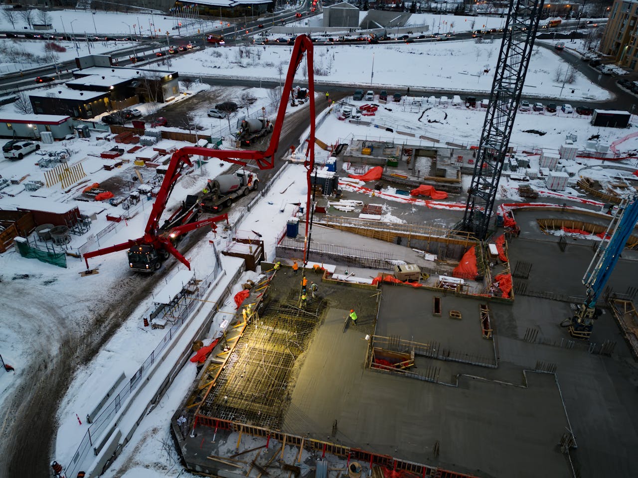 Drone shot of a snowy construction site with heavy machinery in Ottawa, Canada.